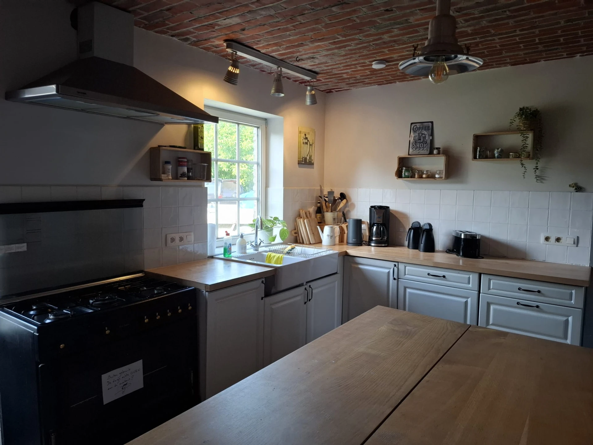 De ingerichte gemeenschappelijke keuken met houten tafel en koffiehoek