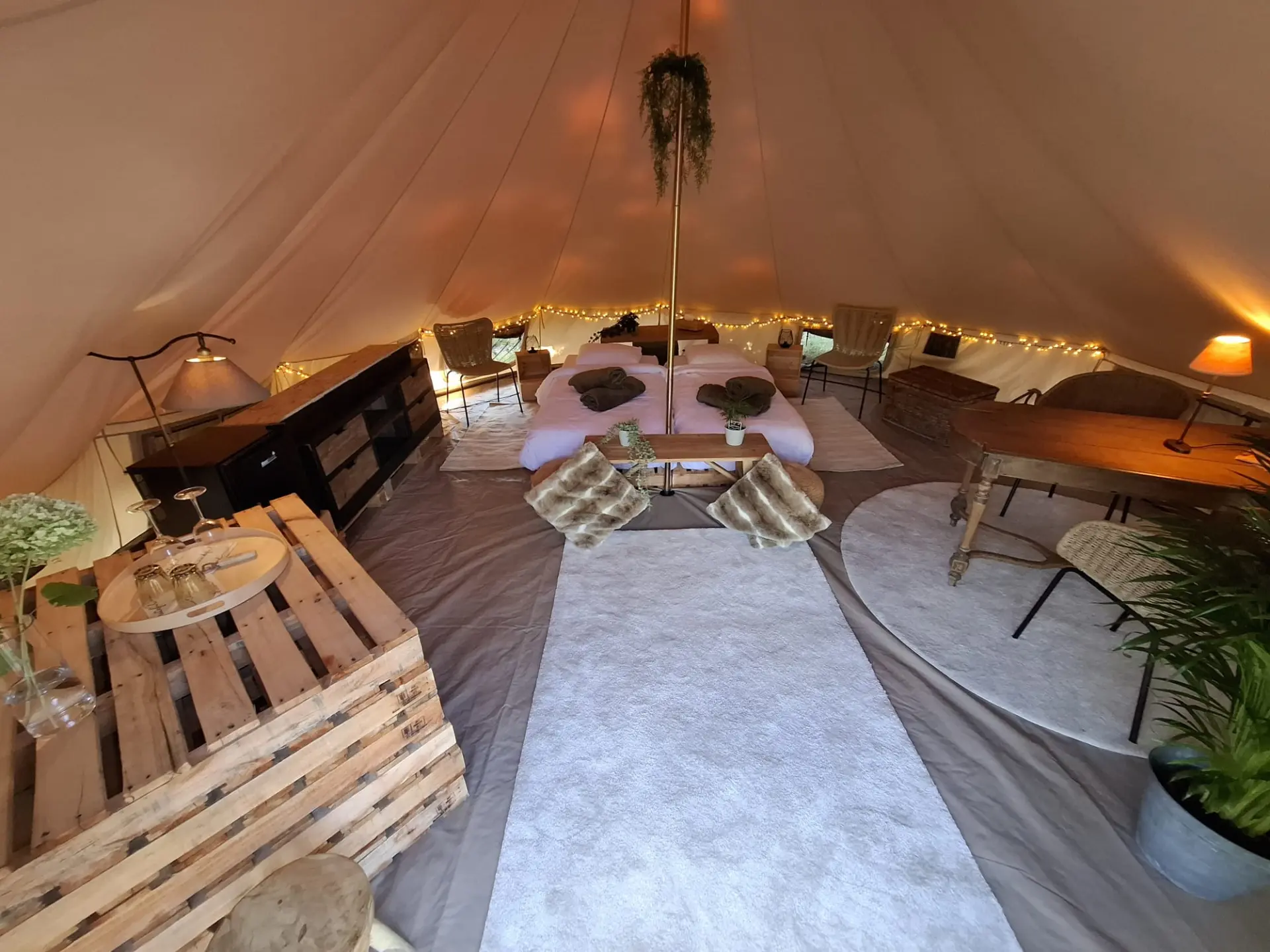 Volledige inrichting van de glampingtent met bedden, kast en eettafel